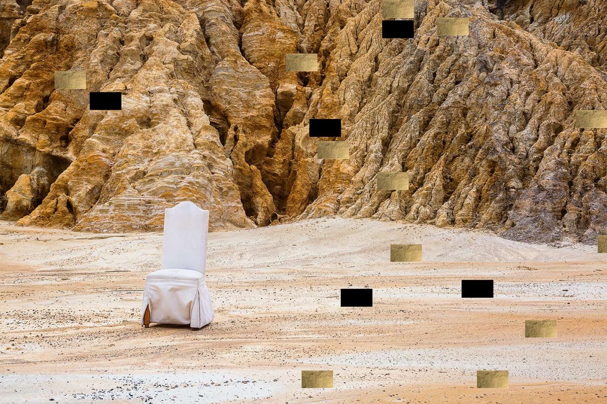 A white cloth covered chair sits in a sand covered ravine