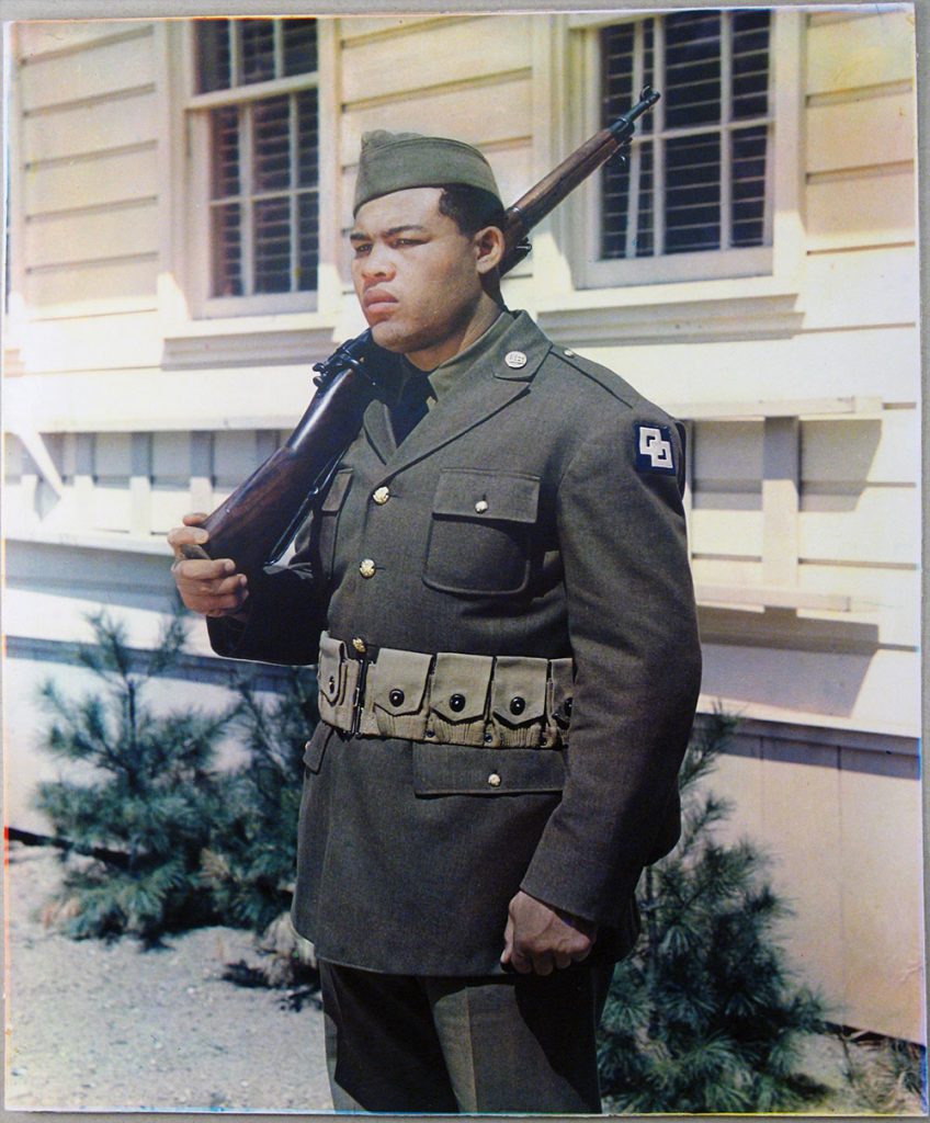 Joe Louis standing in at attention in his Army uniform