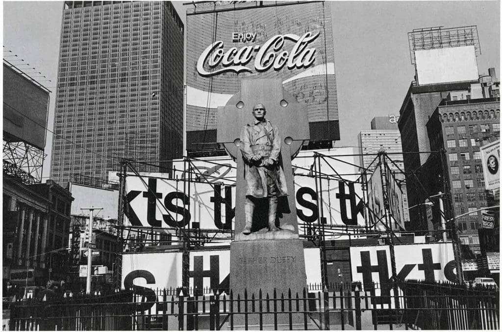 A statue of Father Duffy in the middle of Time Square, NY