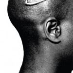 An African American male with a Nike swoosh branded to his shaved head.