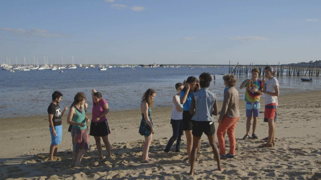 teens gather together on the beach