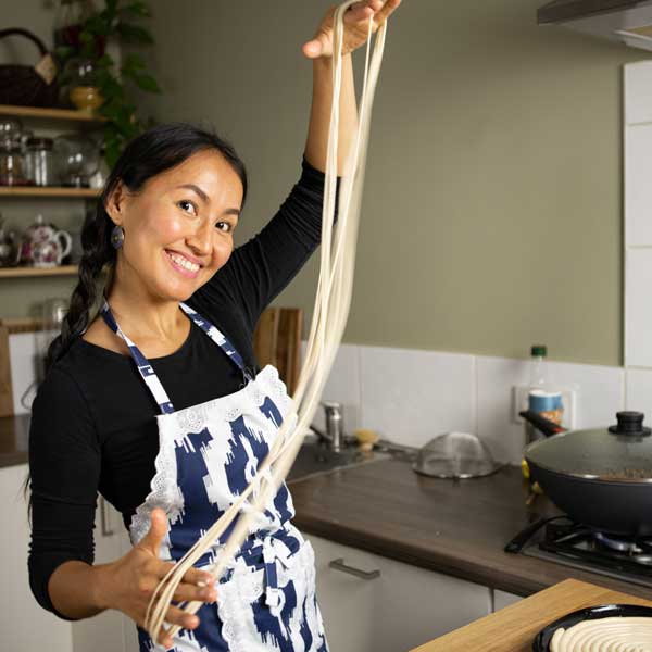 Aliya demonstrates making hand drawn noodles