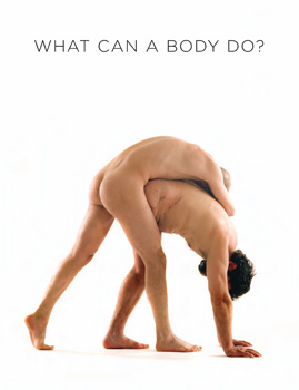 Side view of naked 1-legged man in triangle position with a naked man draped over him, creating a 3-legged effect.